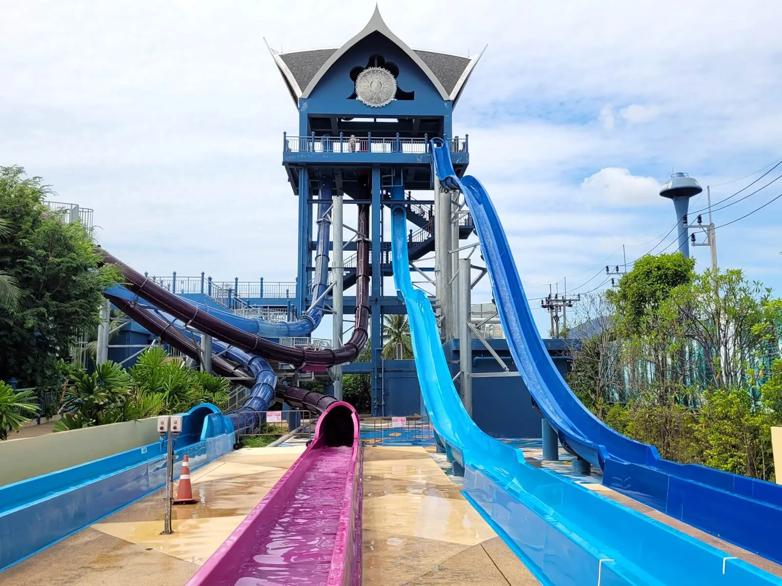 Thai-roofed slide tower with enclosed flumes and open speed slides